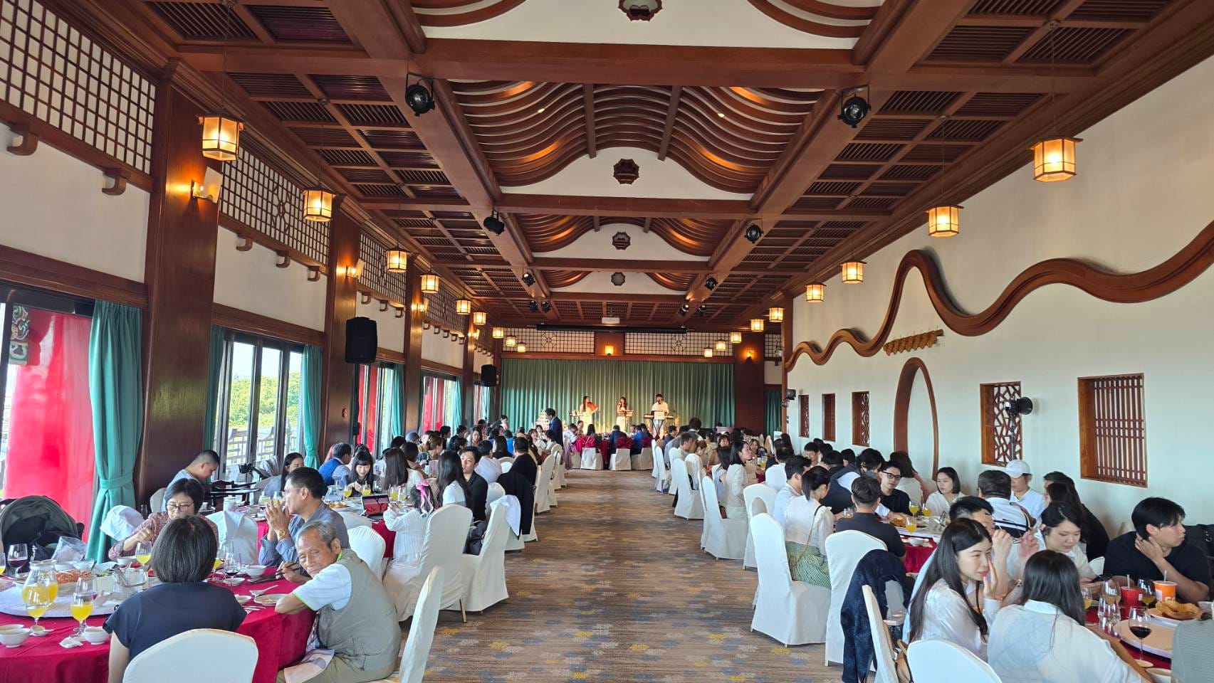 台北圓山飯店婚宴午宴,賓客於宴會廳用餐,遠處可見三人樂團演出