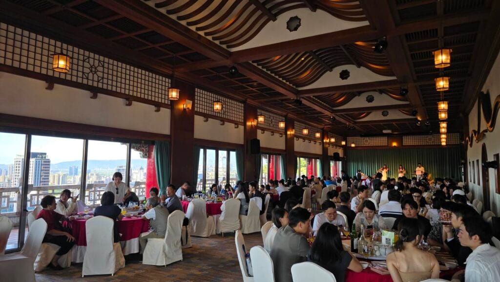 圓山飯店午宴賓客與遠方舞台上的三人樂團演出全景