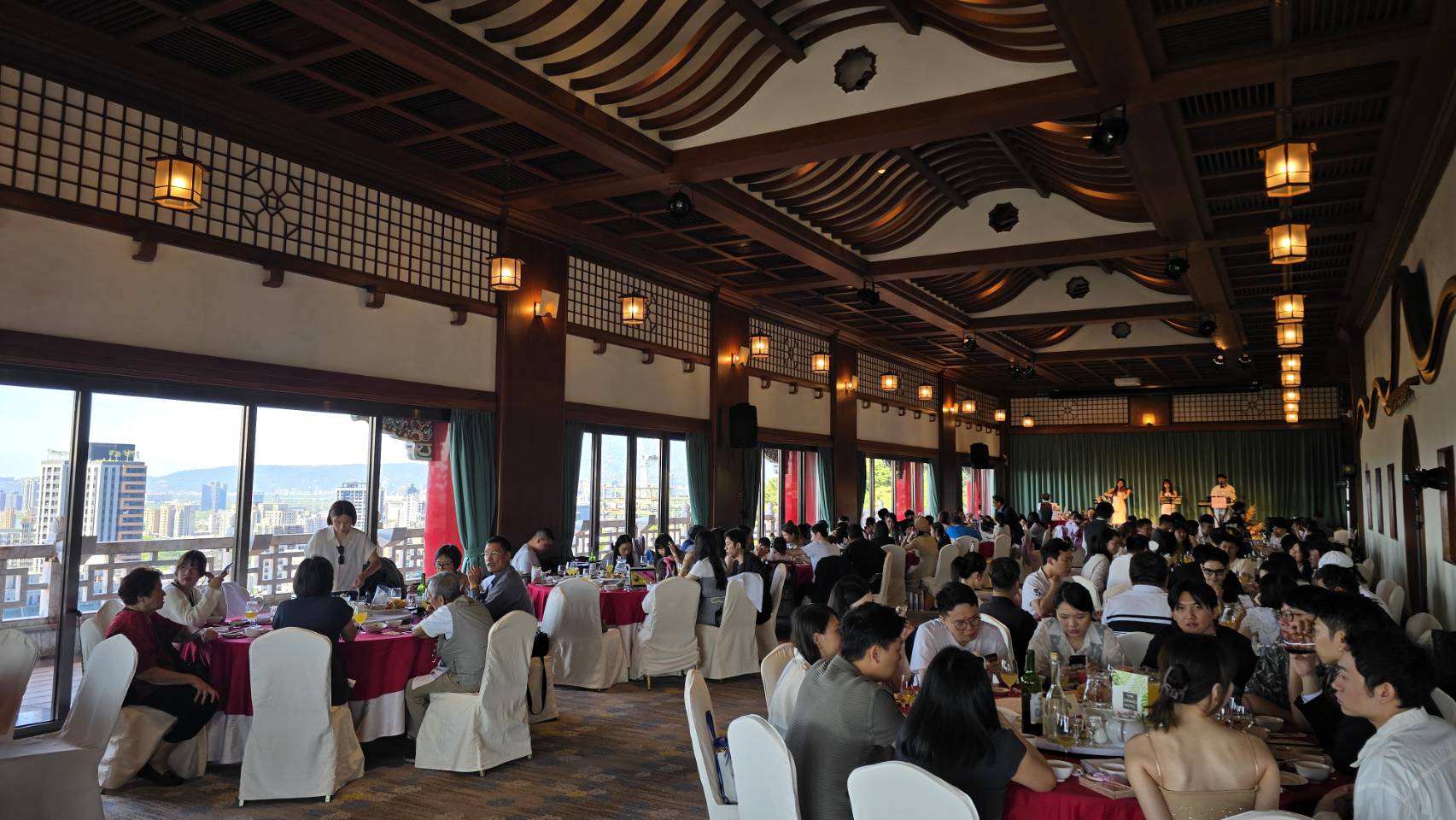 圓山飯店午宴賓客與遠方舞台上的三人樂團演出全景