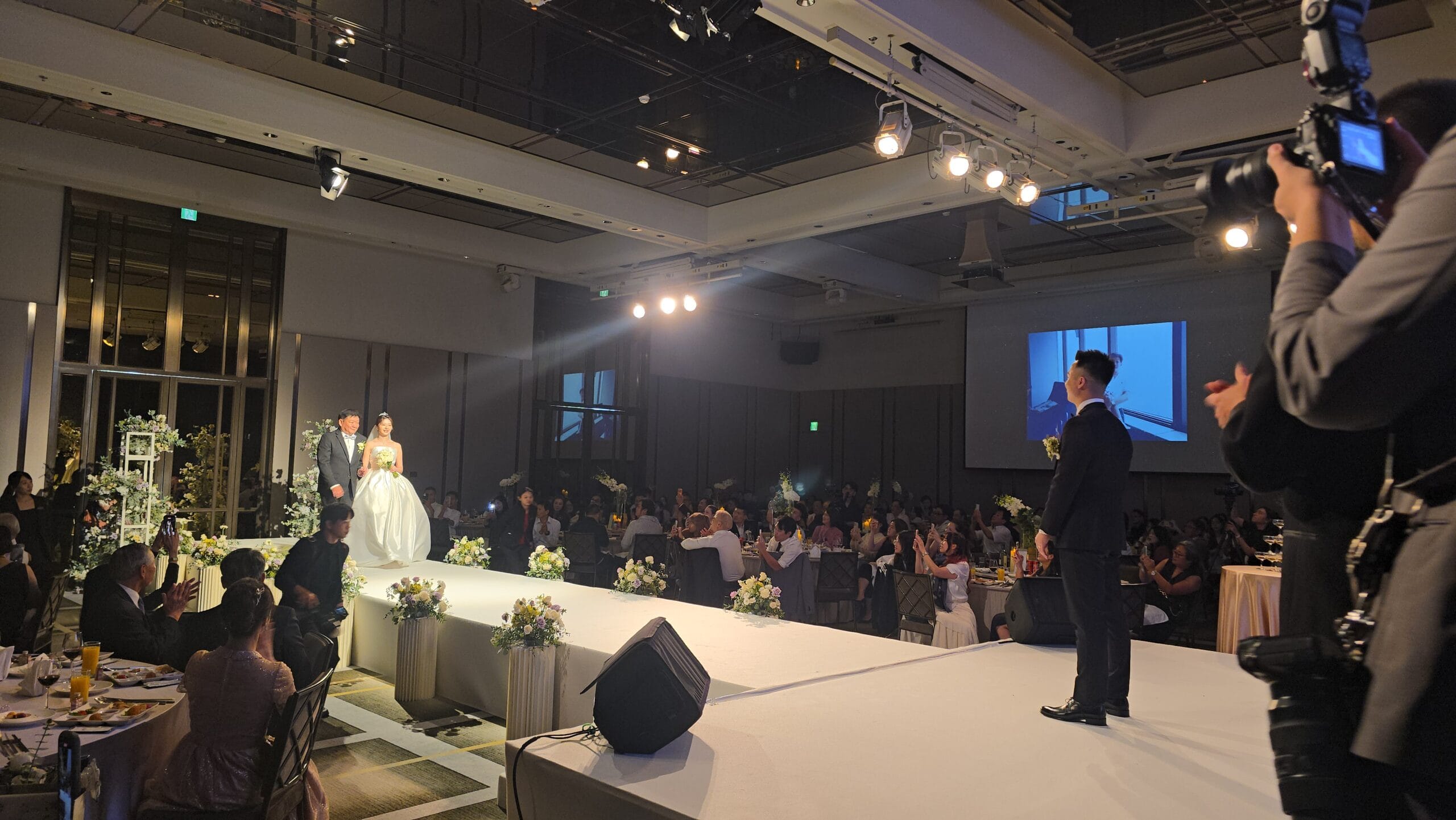 新人步入台北萬豪酒店婚宴會場，賓客於兩側迎接
