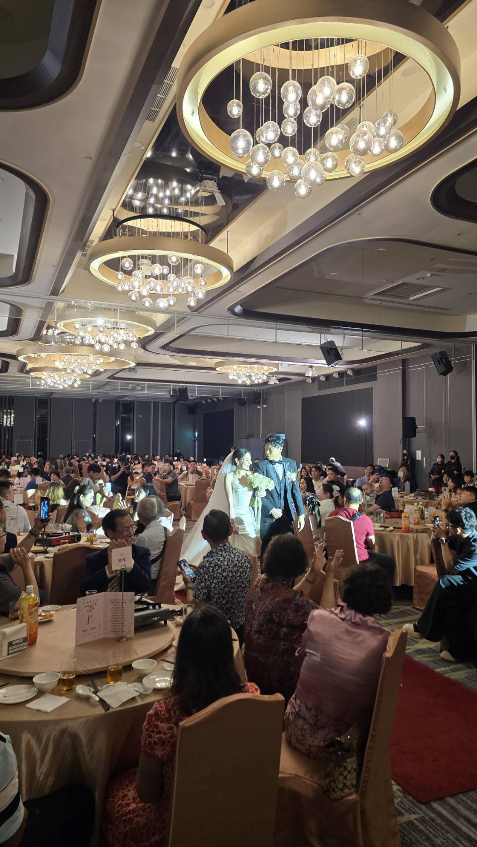 婚宴新人進場，賓客在席間觀禮